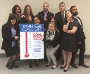 Richard Amantia holds a poster with his fellow students for the 2015 Graduate Class Gift