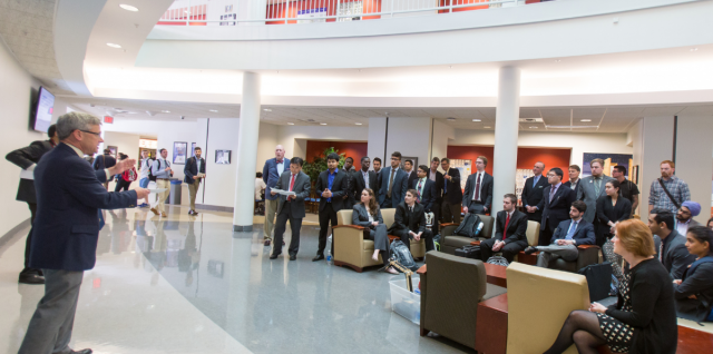 University at Buffalo School of Management students listening to a faculty member in the Alfiero atrium