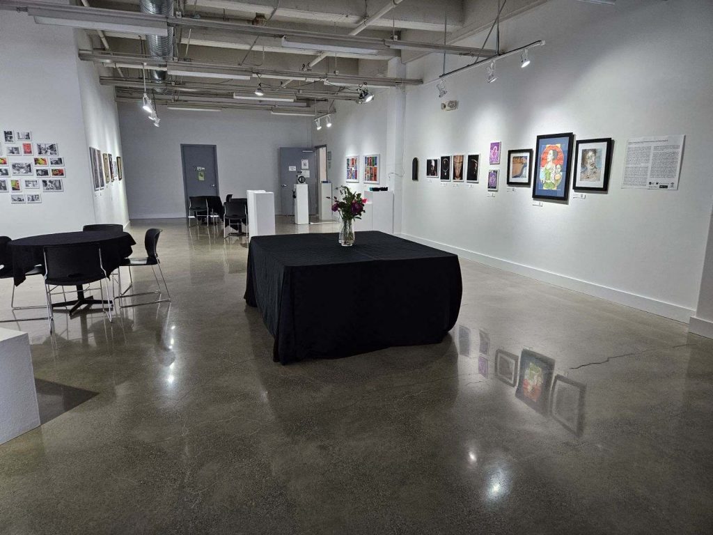 An image of the gallery space before people arrived on opening night. A large table for food sits in the middle of the space.