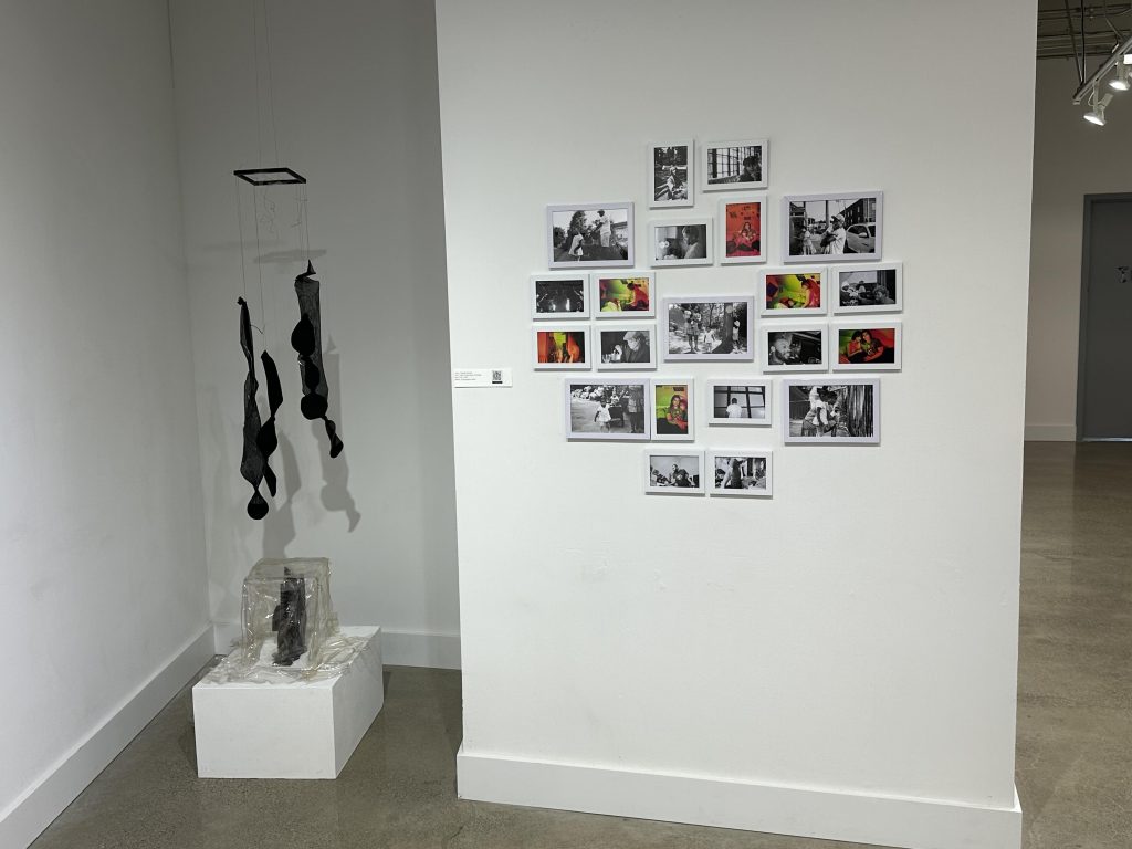 An image of installation art and photos on the walls of the gallery.