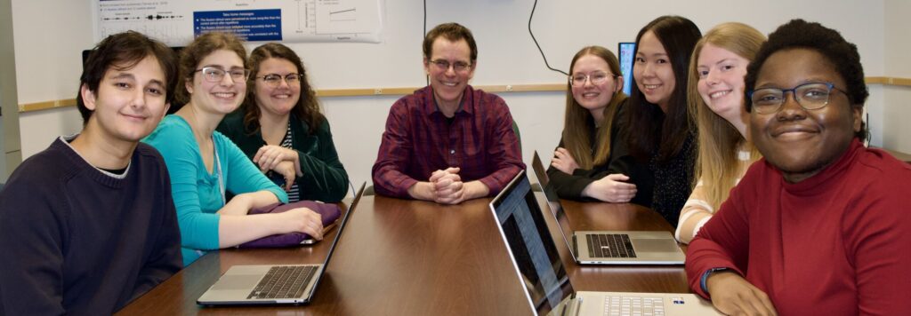 A lab meeting showing eight members of the team working together.