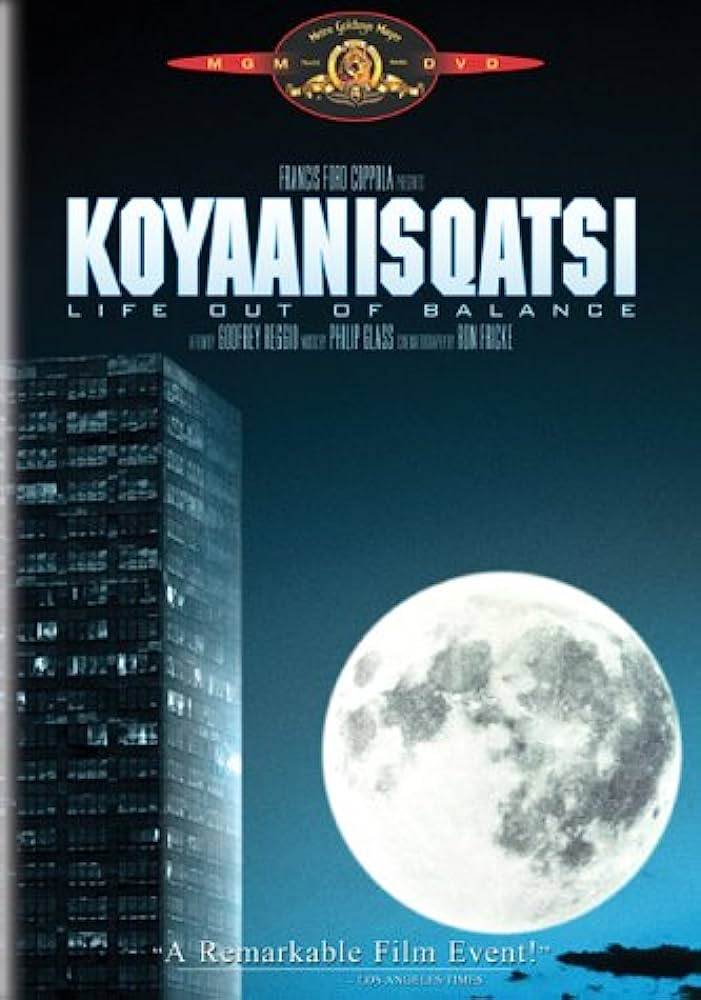 Movie: Koyaanisqatsi (1982). Full moon next to a tall building.