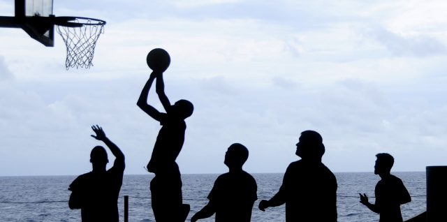 People playing basketball in silhouette