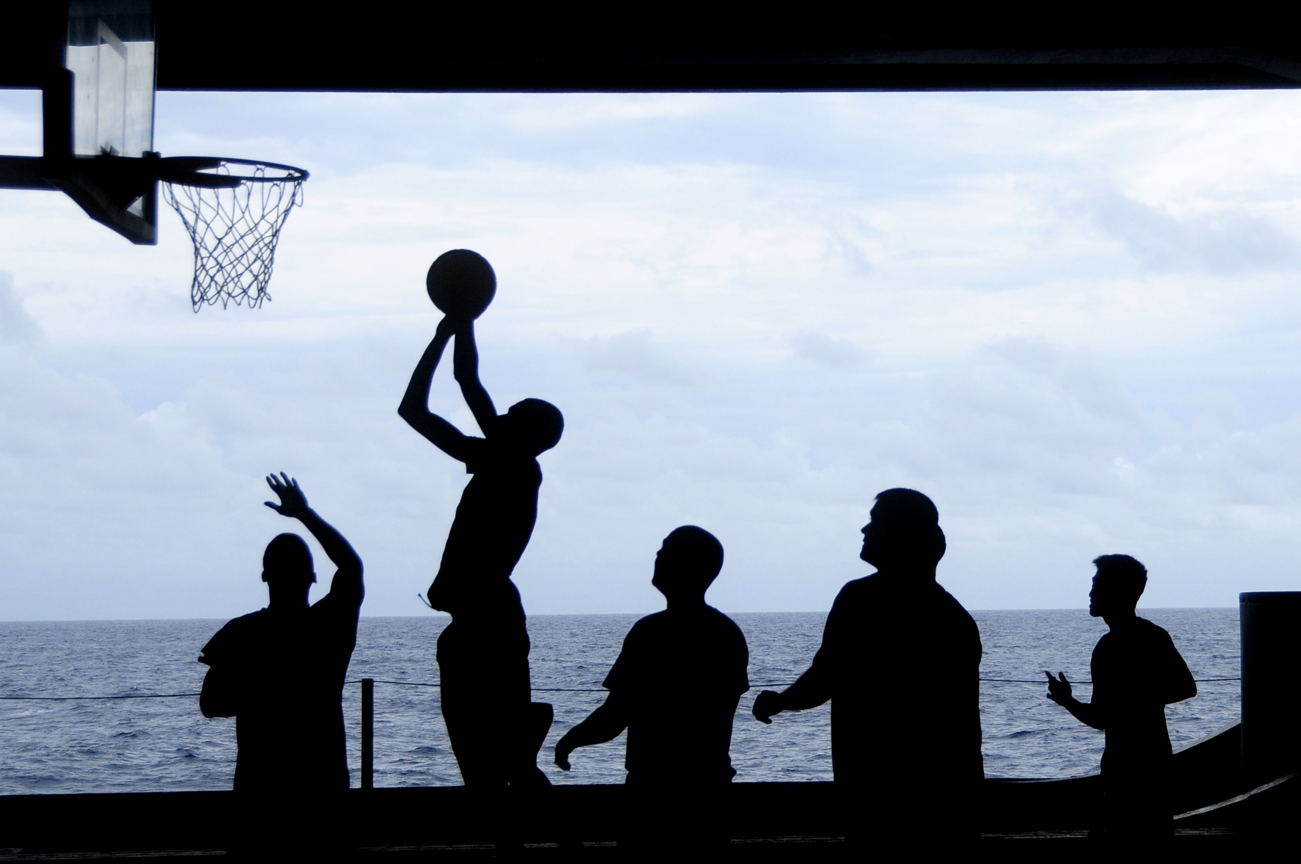 People playing basketball in silhouette