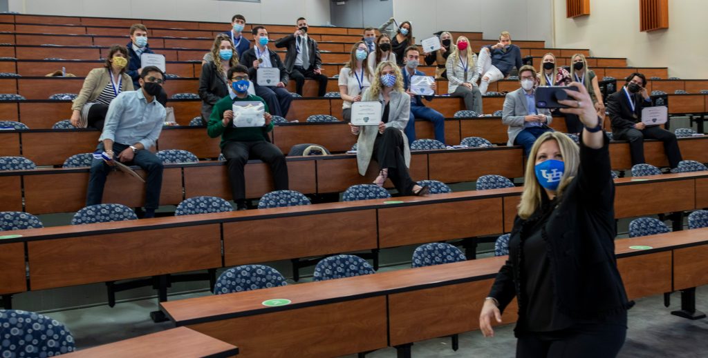 Jaimie Falzarano takes a selfie with the MBA LeaderCORE Class of 2021 behind her.