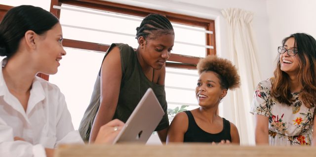 Four women work together on a project.