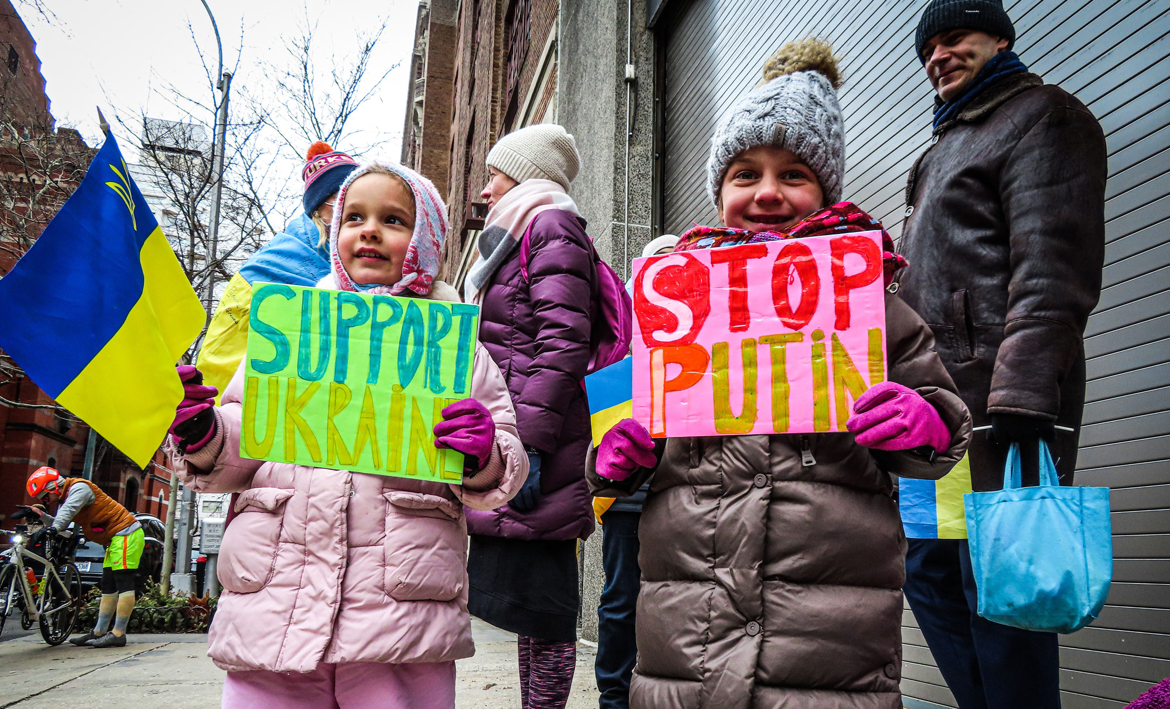 Children hold signs that say "Support Ukraine" and "Stop Putin."