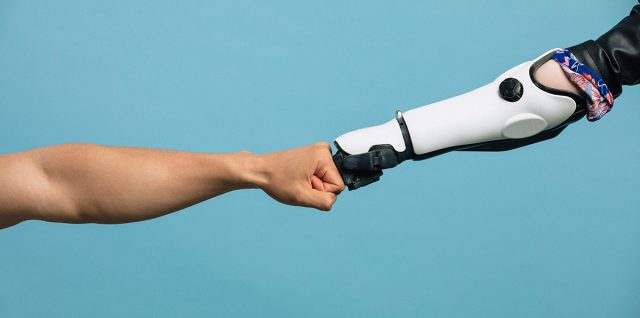 Human and robot arm doing a fist bump