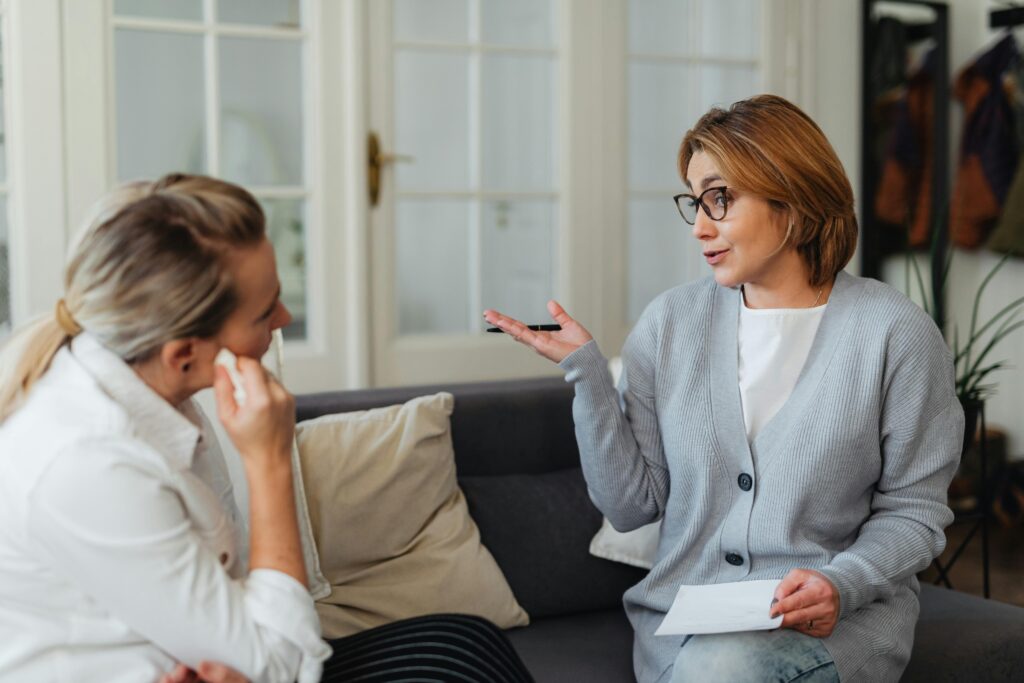 Two colleagues having a discussion in a home setting.