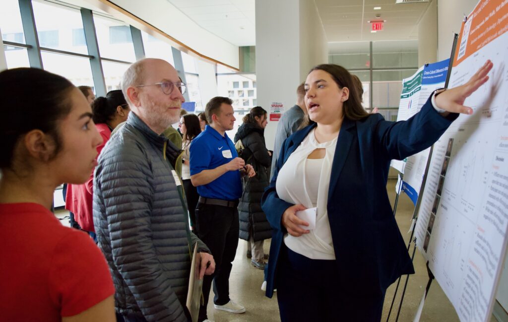 A student presenting their poster