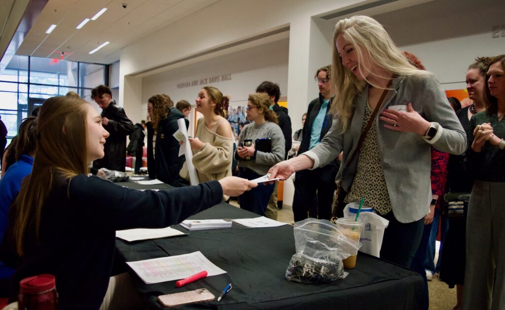 Faculty judge Caitlin Szalkowski checking in at the conference registration table