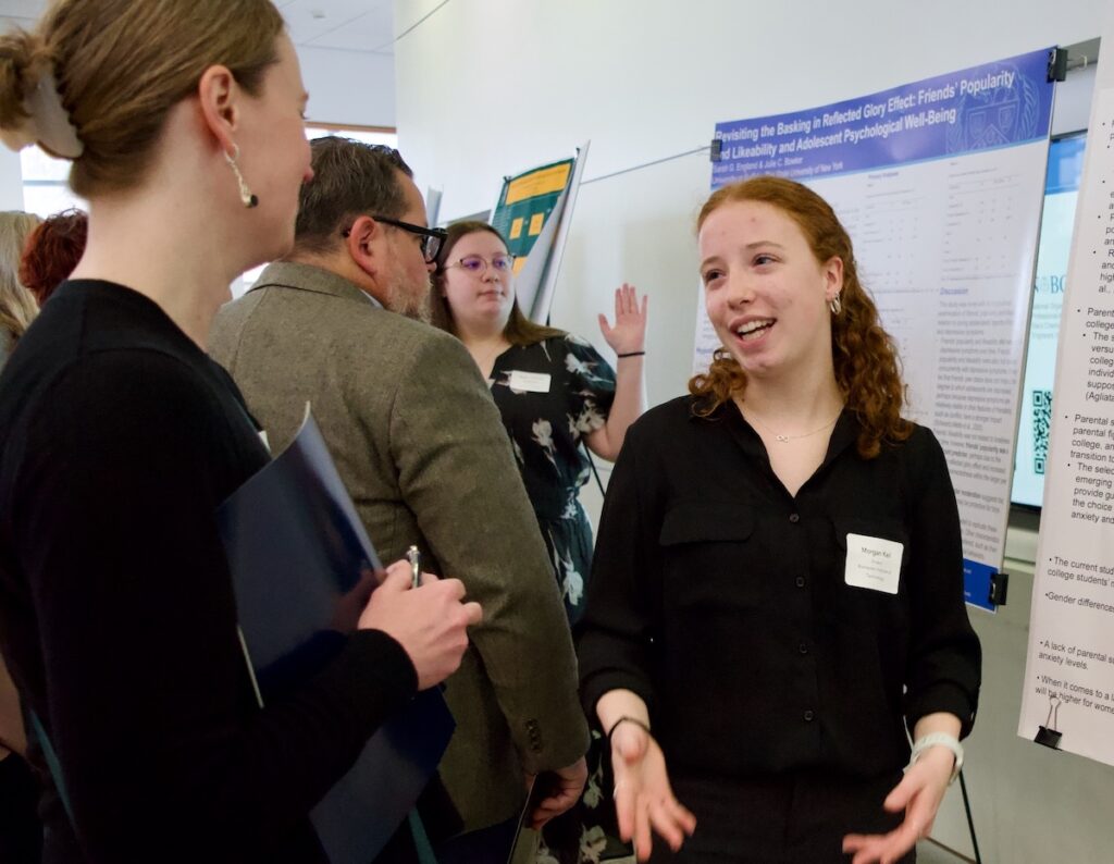 Morgan Keil presenting their poster to a faculty judge